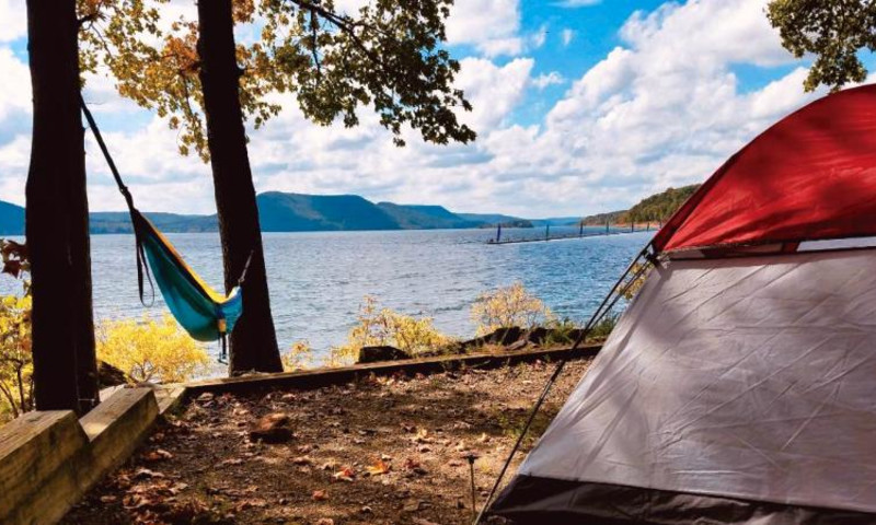 A tent and hammock set up by the shore of Greers Ferry Lake.
