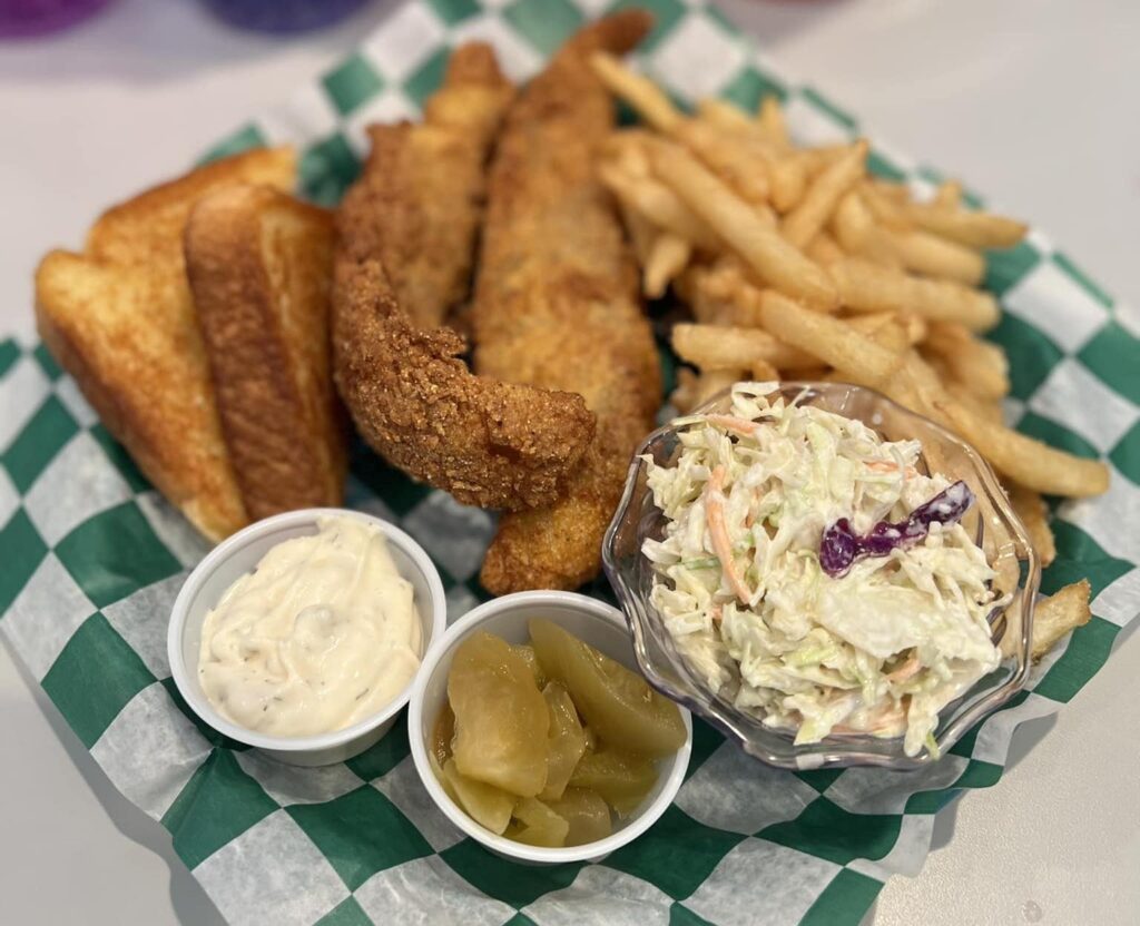 Fried fish with tartar sauce, french fries, Texas toast, Green tomato relish, and coleslaw.