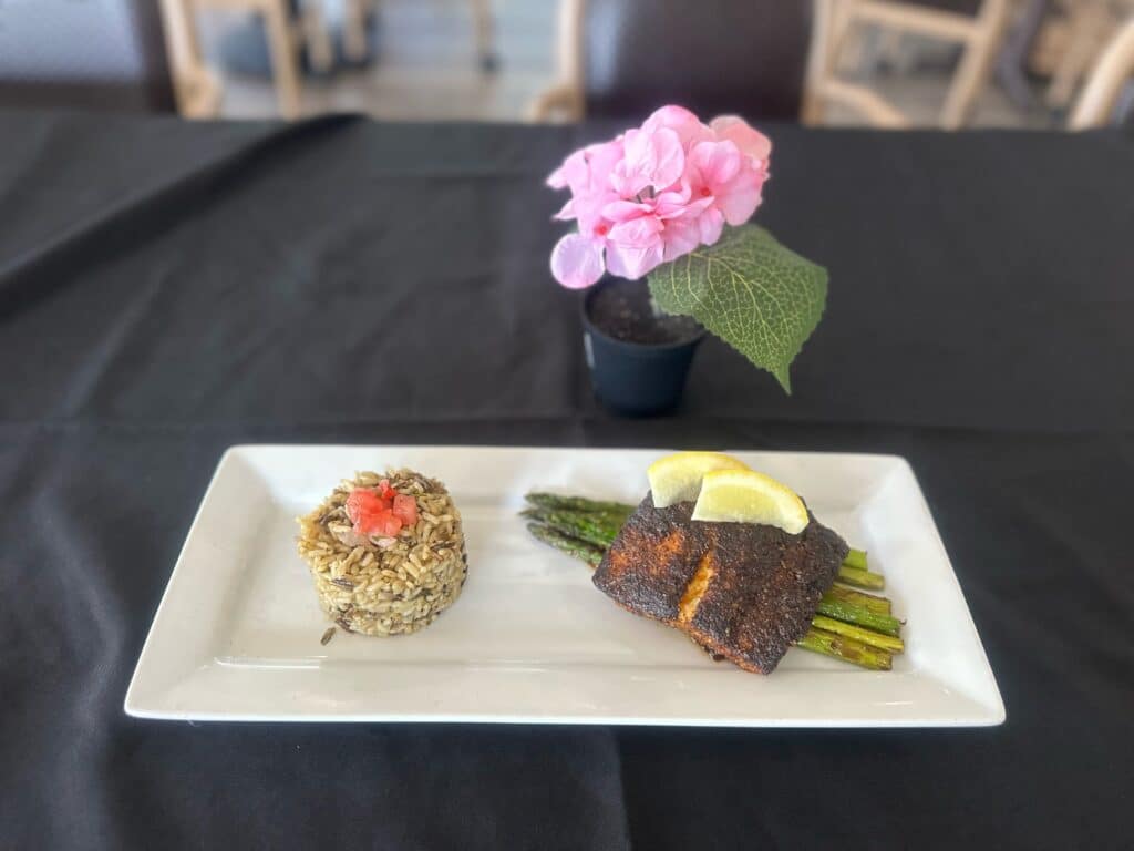 A dish from Little Red Restaurant consisting of rice, blackened salmon, and asparagus.