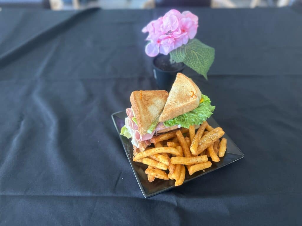 A dish from Little Red Restaurant that consists of a sandwich and french fries.